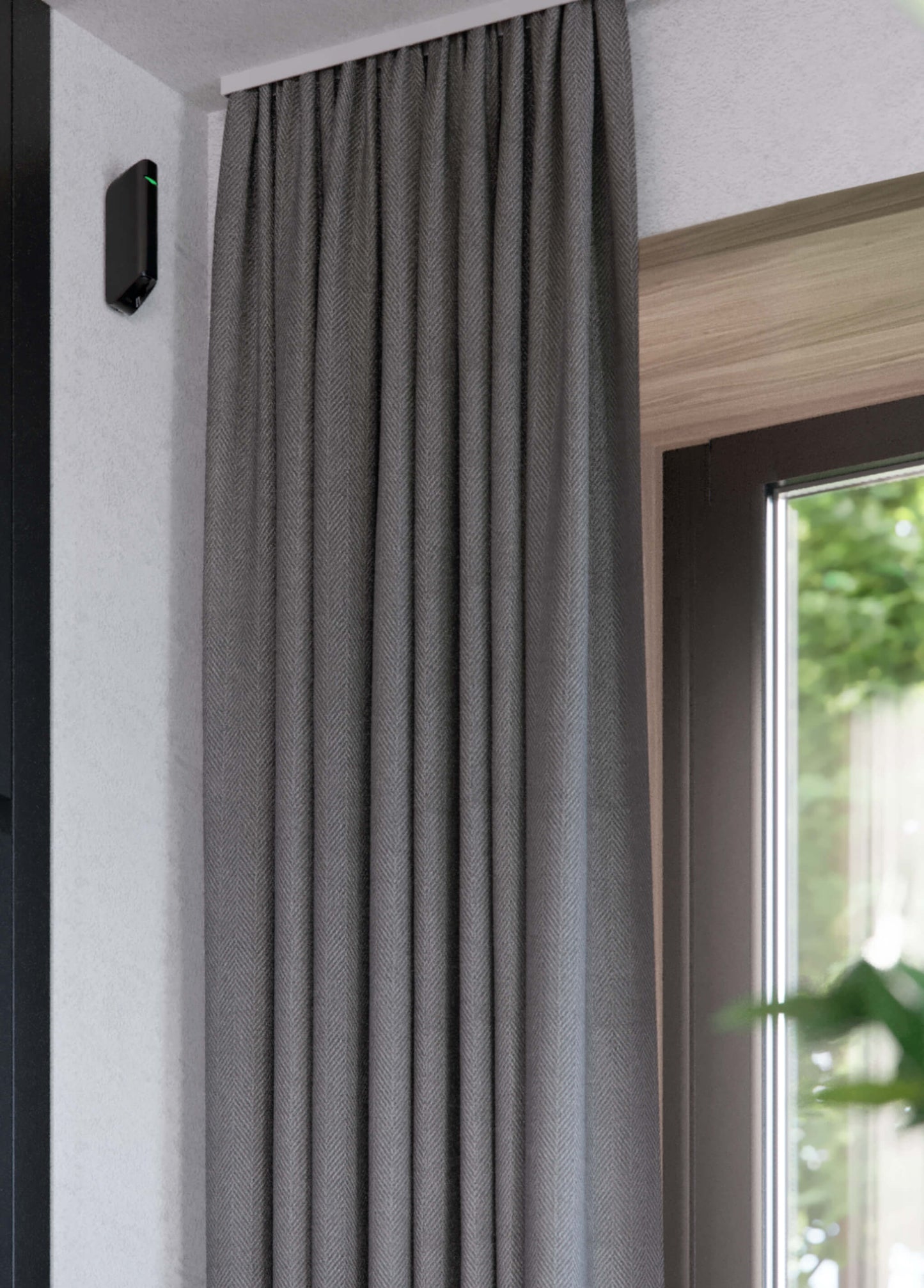 White Ajax MotionProtect Curtain detector a wireless motion detector for business and home security, 134 × 44 × 34 mm in size , 118grams in weight, Side view of device instaled on a wall by a window to demonstrate it in operation.