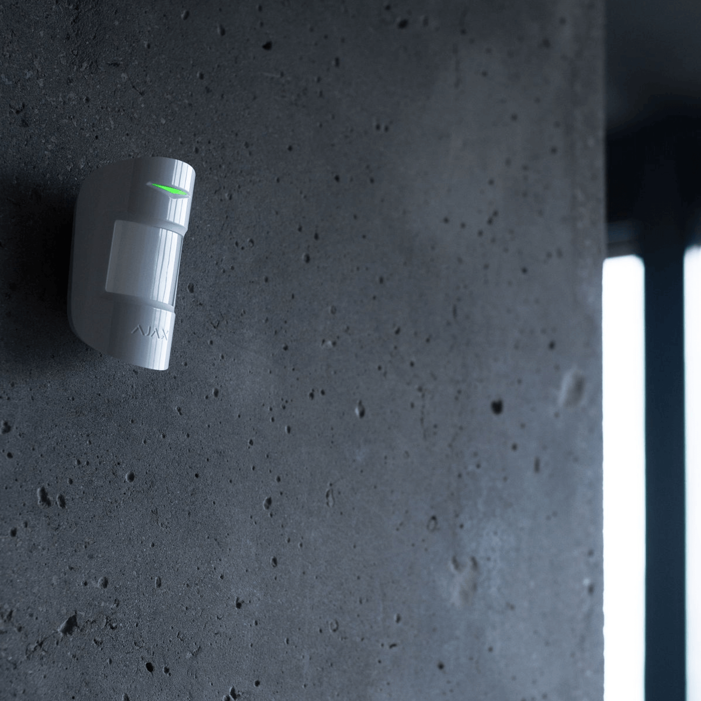 White Ajax MotionProtect wireless motion sensor from Ajax Security Systems, 110 × 65 × 50 mm in size, 86grams in weight . for smart home and business security, side view of device mounted on a wall to deomonstrate the device in operation using Jeweller technology